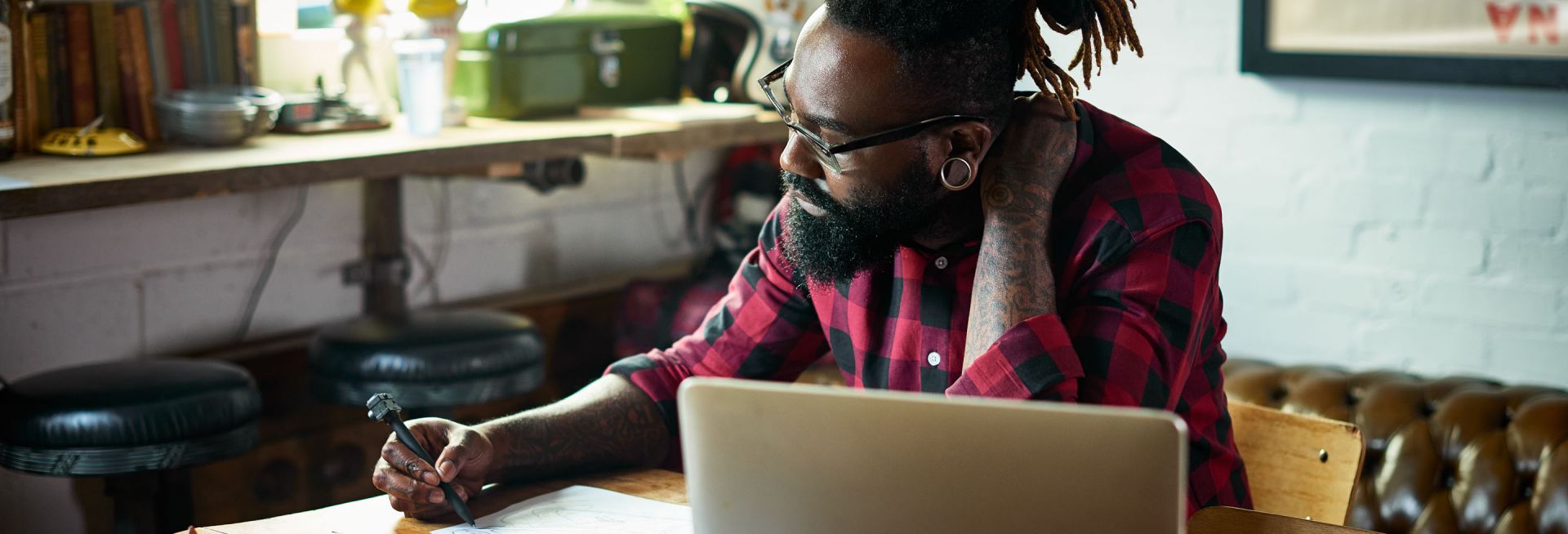 A man is writing with a laptop