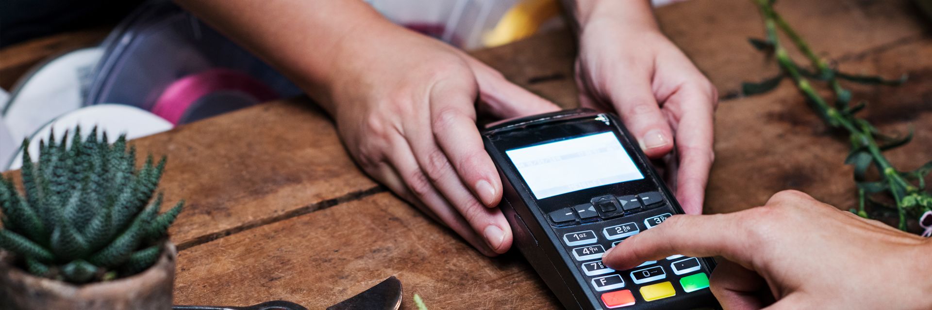 A customer enters their card pin on a shop card reader 