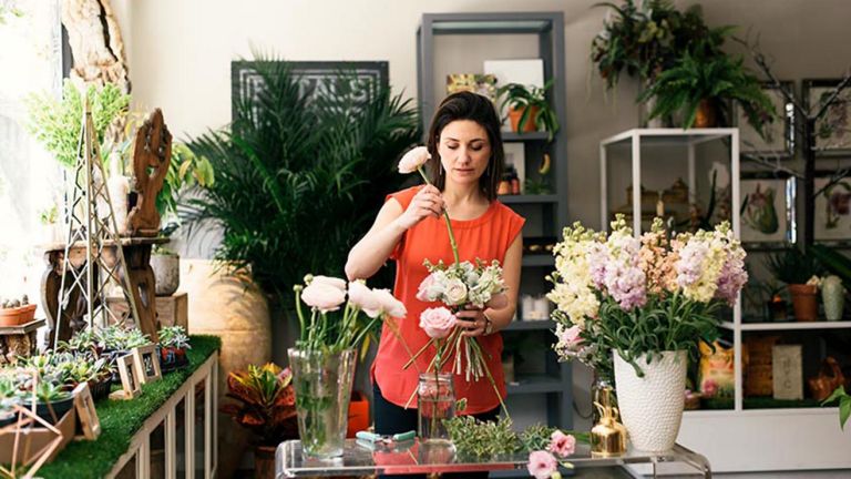 A woman is arranging flowers.